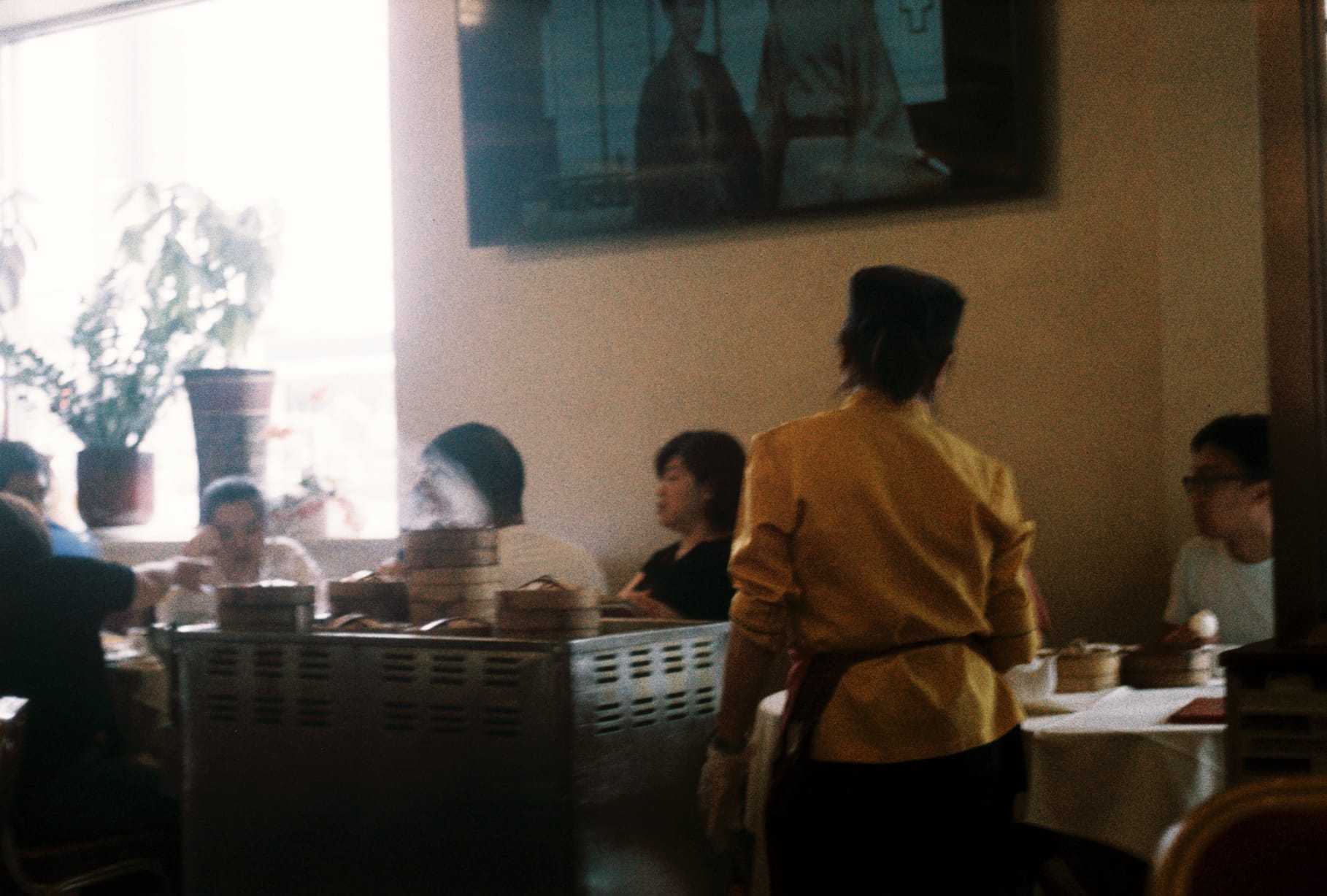A waiter rolls a metal cart of 点心 (dim sum), traditional Cantonese food, across the carpeted restaurant floor here. This is the restaurant my dad has worked at for nearly 10 years; he's been in the service industry for 25 years now. On any Sunday, if you happen to stumble here, it'll be an hour long wait before you can get seated. Located in a neighborhood of immigrants, primarily from the Canton and Fujian province that came in the 1980s, that's how much food means to our community. We will do anything to feel at home away home.
